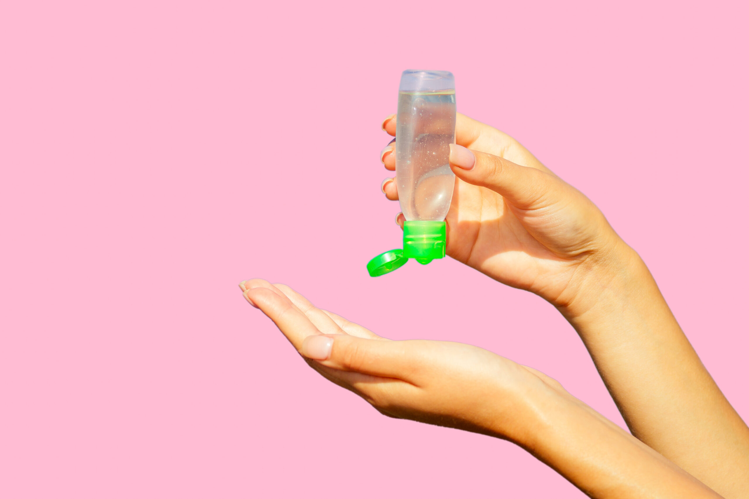 pair of hands pouring antiseptic lotion into the palm of the hand