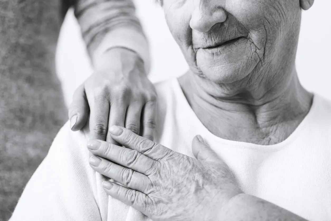 older woman with hand on chest
